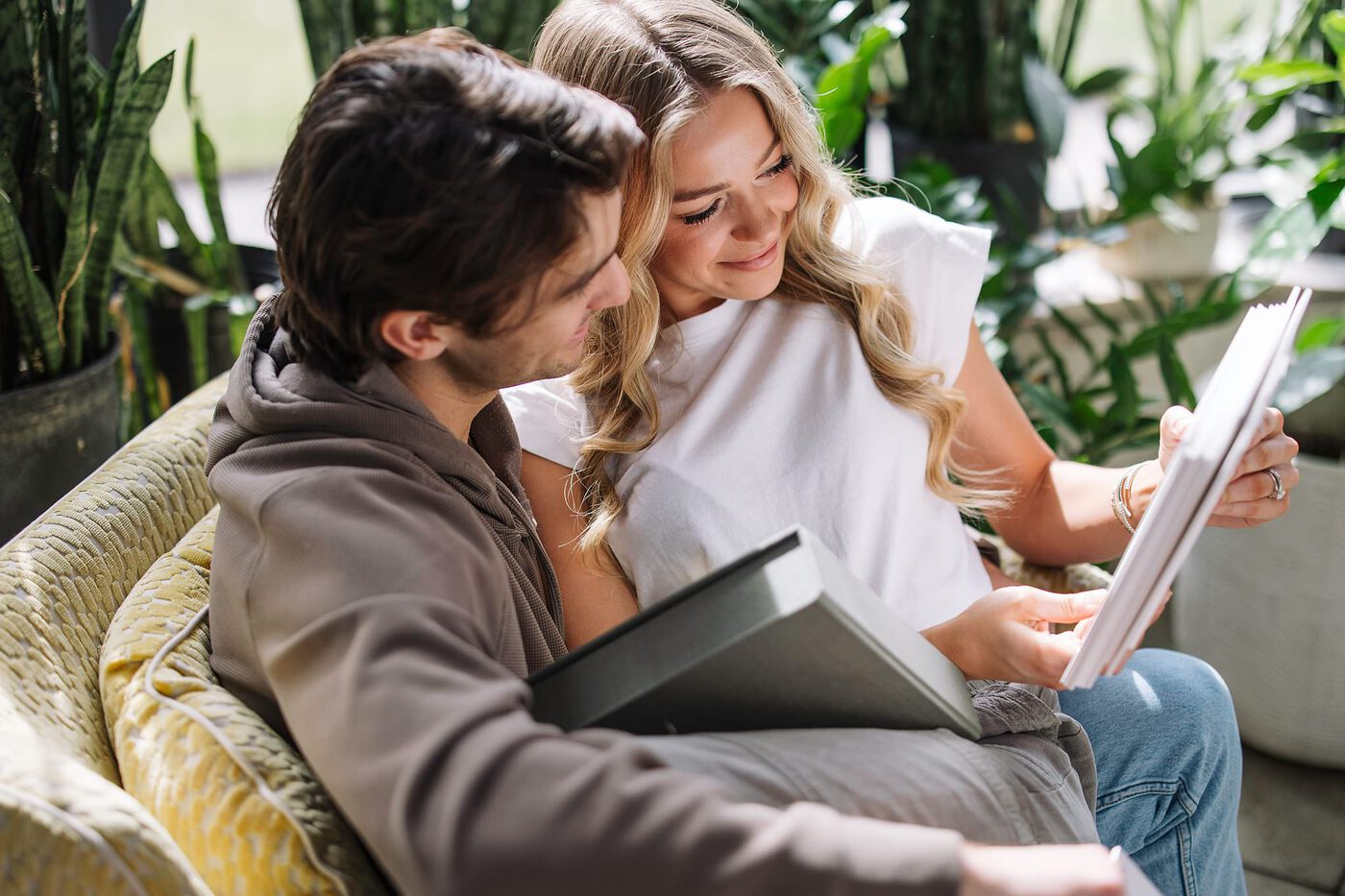 A couple looking through an open album together on the couch